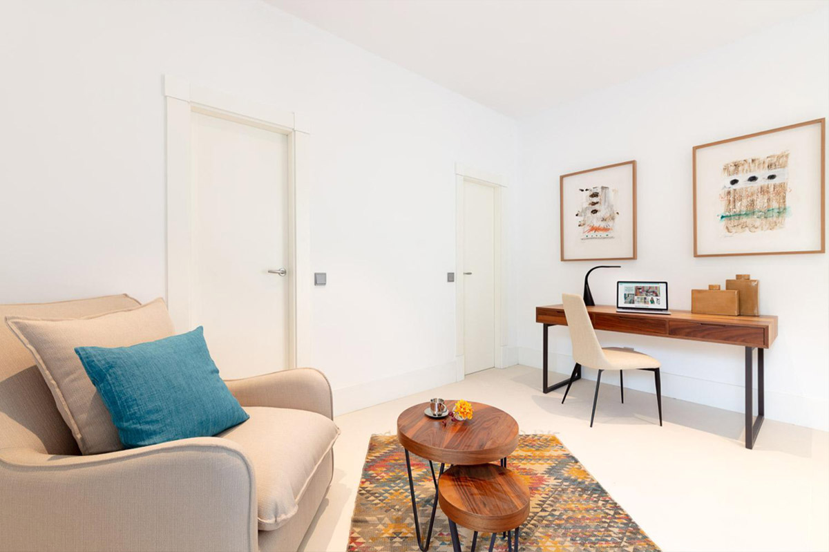 Reading corner with a comfortable armchair, turquoise cushion and wooden desk