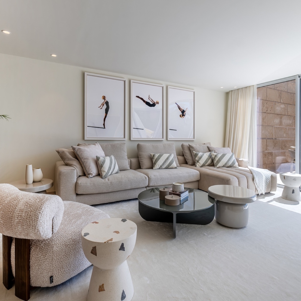 Light-filled living room with a neutral sofa, sculptural tables and terrace access