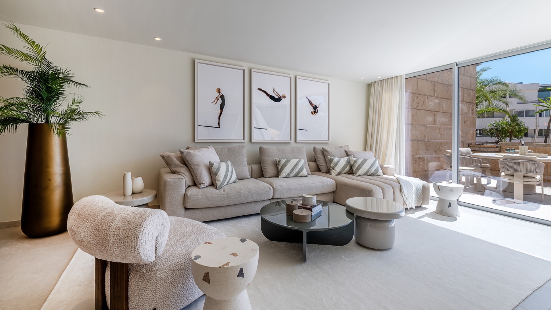 Light-filled living room with a neutral sofa, sculptural tables and terrace access