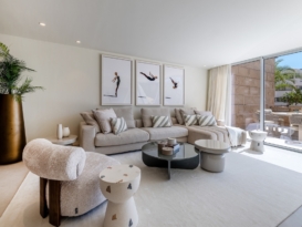 Light-filled living room with a neutral sofa, sculptural tables and terrace access